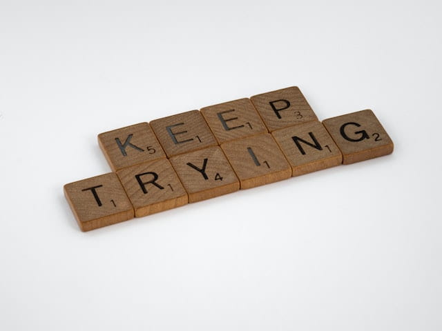 "Keep Trying" spelled out using wooden scrabble pieces